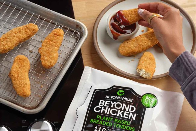 Beyond Chicken Tenders on a baking rack and a person's hand dipping a tender in barbecue sauce