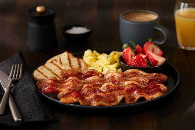Plate of bacon, eggs, fruit, and toast