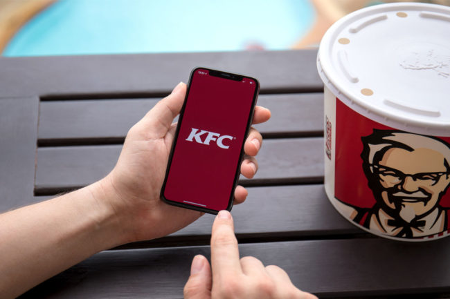 Person holding phone with KFC logo