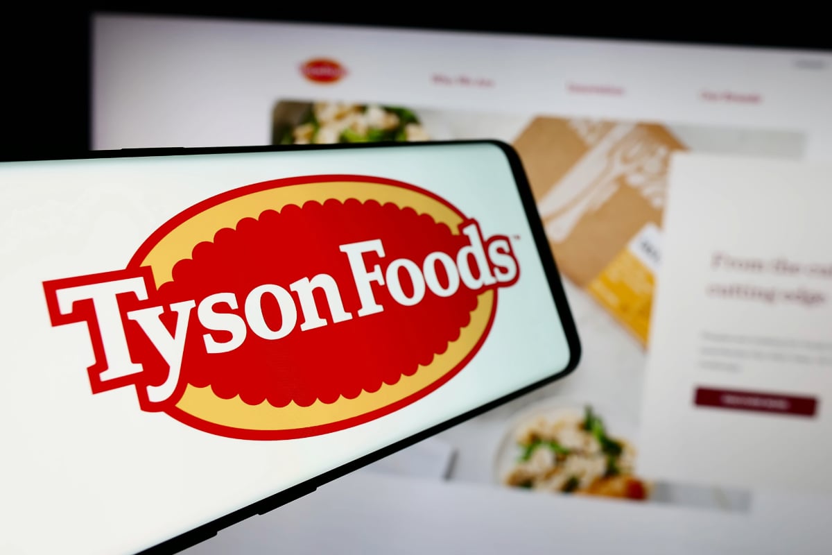 Tyson Foods logo on smart phone with website on desktop in background